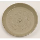 A Chinese moulded kui dragon plate, 20th century, the circular dish with a raised knob to the cen...