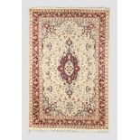 An Indian Kashmir carpet, the central medallion surrounded by floral motifs and swags, on a cream...