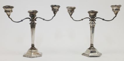 A pair of silver two branch candelabra, Birmingham, one 1966 and the other 1967, Sanders & Macken...