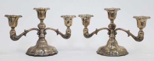 A pair of three light candelabra, stamped STERLING, raised on shaped pedestals, engraved with ini...