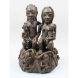 A modern terracotta figural group, Nigeria, depicting a family scene with a father and mother sea...