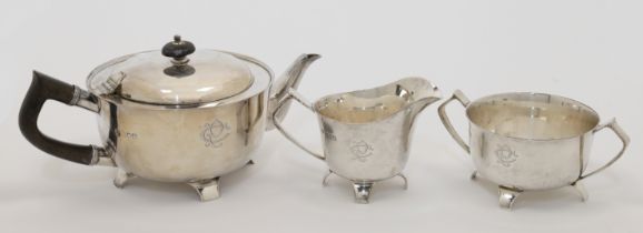 An Edwardian three-piece silver tea set, comprising: a tea pot, a cream jug and a twin handled su...