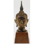A Thai gilt bronze head of a buddha or bodhisattva, 19th century, the serene face with lowered ey...