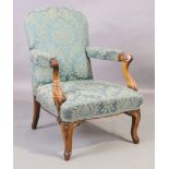 A Victorian walnut armchair, third quarter 19th century, with floral upholstery and scrolling arm...