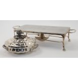 A white metal hot plate on a silver plate stand with burner, the removable hot plate of rectangul...