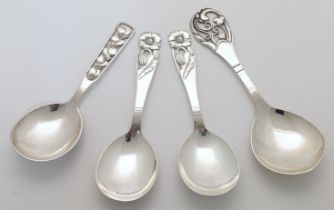 A small group of Danish white metal serving spoons, 20th century, each pierced and decorated with...