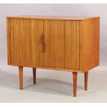 A Danish teak tambour fronted side cabinet, c.1950, the tambour doors enclosing storage space and...