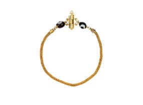 A woven gold chain anklet with agate beads, after the Antique, the two eye beads either side of a...