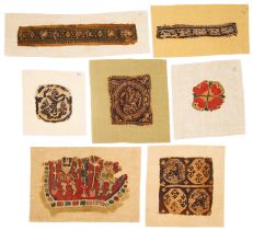 Seven Coptic fragmentary textiles, Circa 4th-9th Century A.D., Five woven in reddish brown wool o...
