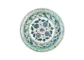 A Timurid blue and white pottery dish, Iran, 14th century, of shallow form, decorated in undergla...