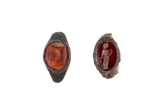 Two Roman carnelian intaglios, circa 1st-3rd Century A.D., both set within their original bezels,...