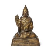 A Tibetan gilt-bronze figure of a Gelug lama 18th century Finely cast with serene, downcast exp...