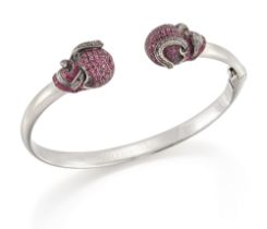 Theo Fennell. A ruby and black diamond skull bangle, of hinged torque design, with confronting sk...