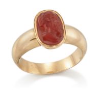 An early 19th century gold cornelian cameo ring, in the Roman style with central carved oval came...