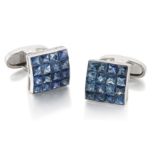 A pair of 18ct white gold sapphire cufflinks, the slightly curved panel with a grid of invisibly ...