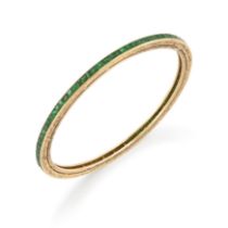 An emerald bangle, a continuous row of channel-set calibré-cut emeralds, to scroll engraved guard...