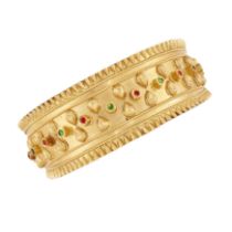 A paste set bangle, with a central row of alternating green and red paste, to raised foliate deco...