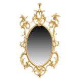An English giltwood wall mirror, of George III style, last quarter 19th century, the moulded oval...