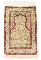 A Turkish silk Hereke rug, signed, second quarter 20th century, the mihrab field with bird, vase ...