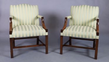 A pair of English mahogany Gainsborough armchairs, George III style, 20th century, with striped u...