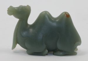 A Chinese celadon jade carving of camel, 20th century, the recumbent animal carved with its legs ...