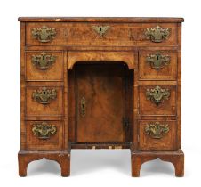 A George I walnut kneehole desk, first quarter 18th century, the crossbanded top above an arrange...