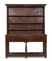 A George III oak dresser, last quarter 18th century, with plate rack back above three drawers to ...