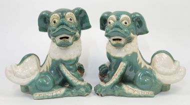 A pair of Chinese terracotta Foo dogs, 20th century, with heads turned to dexter and sinister and...