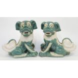 A pair of Chinese terracotta Foo dogs, 20th century, with heads turned to dexter and sinister and...
