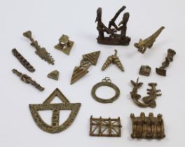 A collection of various African tribal brass weights, amulets and adornments, designed with vario...