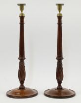 A pair of George III style mahogany candlesticks, 20th century, each with brass urn shaped sconce...