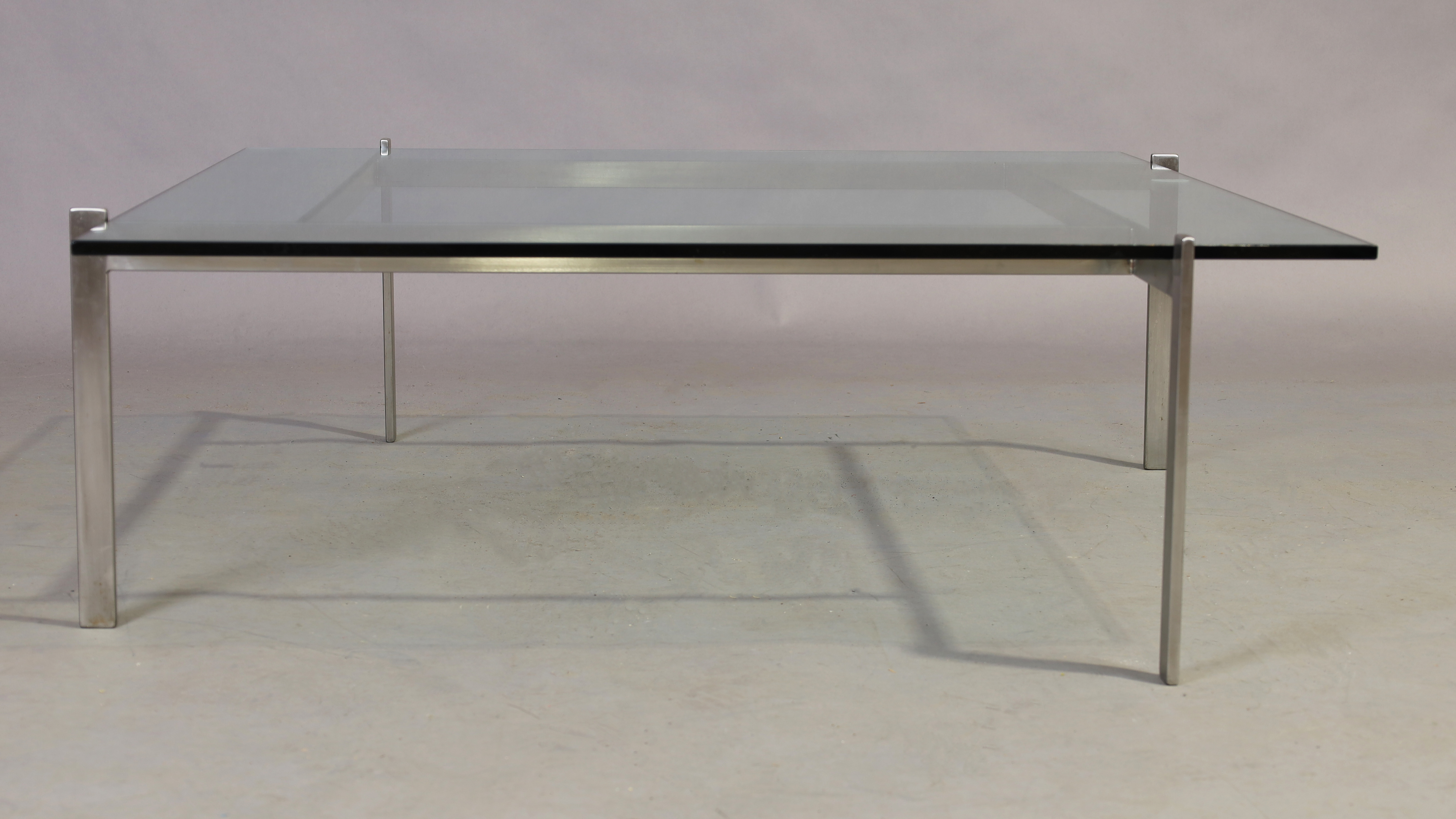 After Poul Kjærholm, a model PK61 style brushed steel and glass coffee table, 34cm high, 103cm wi...