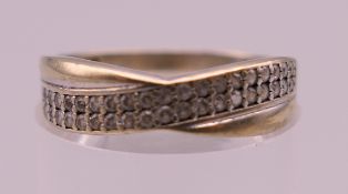 A 9 ct gold diamond set crossover ring. Ring size M. 1.3 grammes total weight.