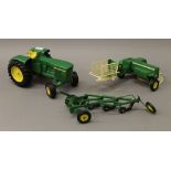 A die cast John Deere tractor, bailer and plough. The tractor 27 cm long.