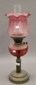 A Victorian brass and cranberry glass oil lamp. 61 cm high overall.