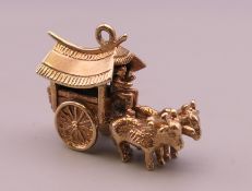 A 9 ct gold charm formed as oxen and a cart. 4.9 grammes.