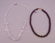 A garnet necklace and a crystal necklace.