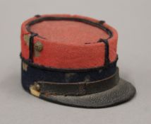 A French helmet form inkwell and a box formed as a hat. The former 3.5 cm high.