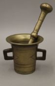 An 18th century brass pestle and mortar. The latter 11 cm high.