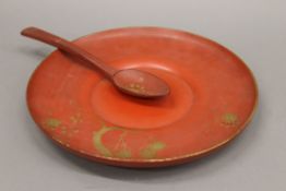 A chinoiserie lacquered plate and spoon. 29.5 cm diameter.