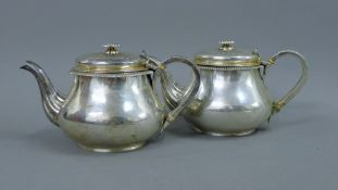 A pair of Georgian silver teapots. 13 cm high. 37.2 troy ounces.