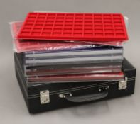 A quantity of coin collectors trays and a case.