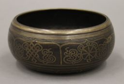 An inlaid bronze singing bowl, inside embossed with five poses of buddha. 12 cm diameter.