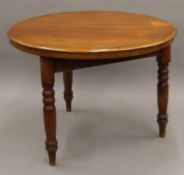A circular mahogany table and bookcase. The former approximately 105 cm diameter.