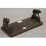 A Blackforest carved bookrack with bear ends. 30.5 cm long when closed.