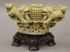 An elaborately carved Chinese soapstone vase surrounded by temple dogs. 25 cm wide.