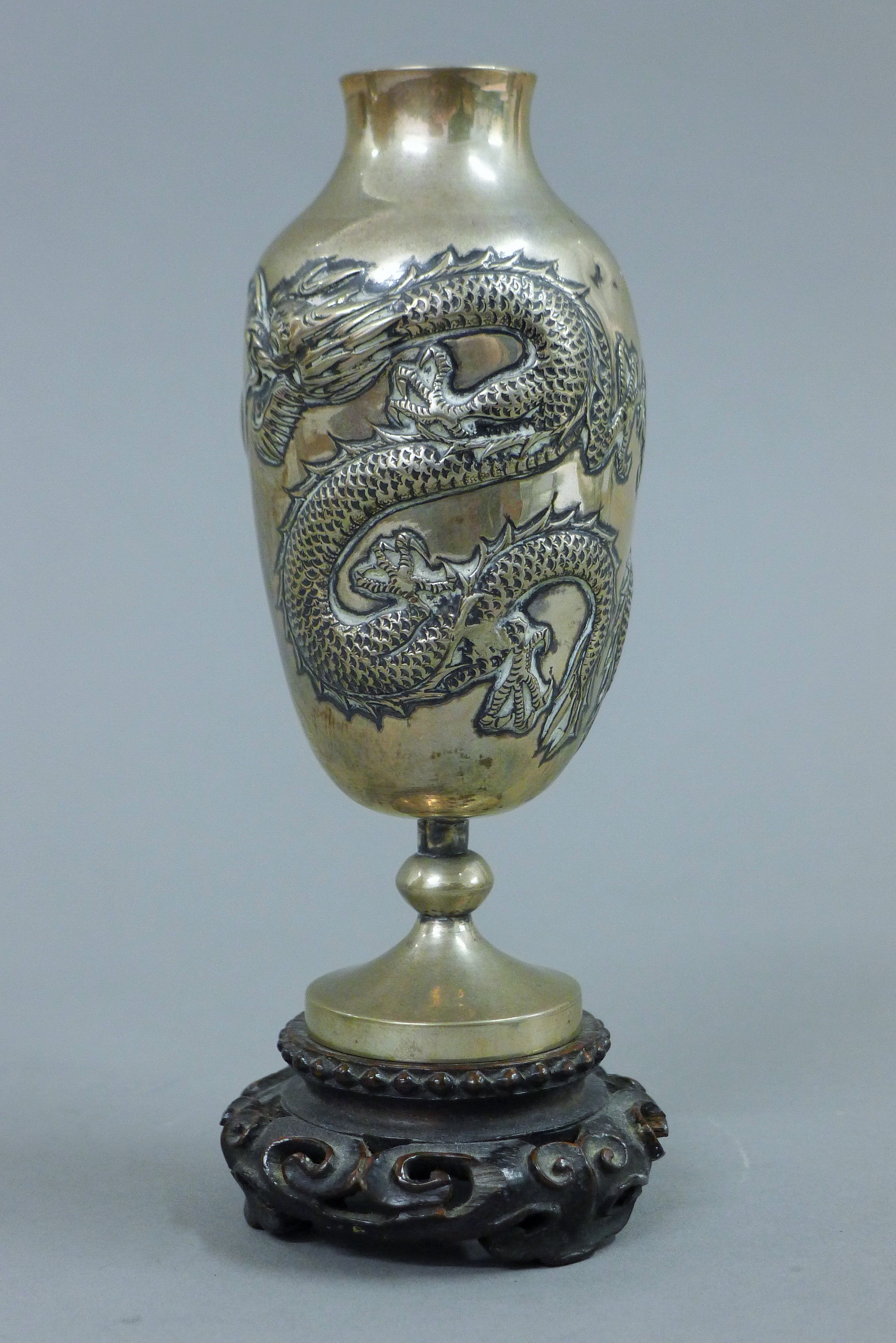 A pair of small Chinese silver vases, each mounted on a carved wooden stand. 14.5 cm high overall. - Image 2 of 5