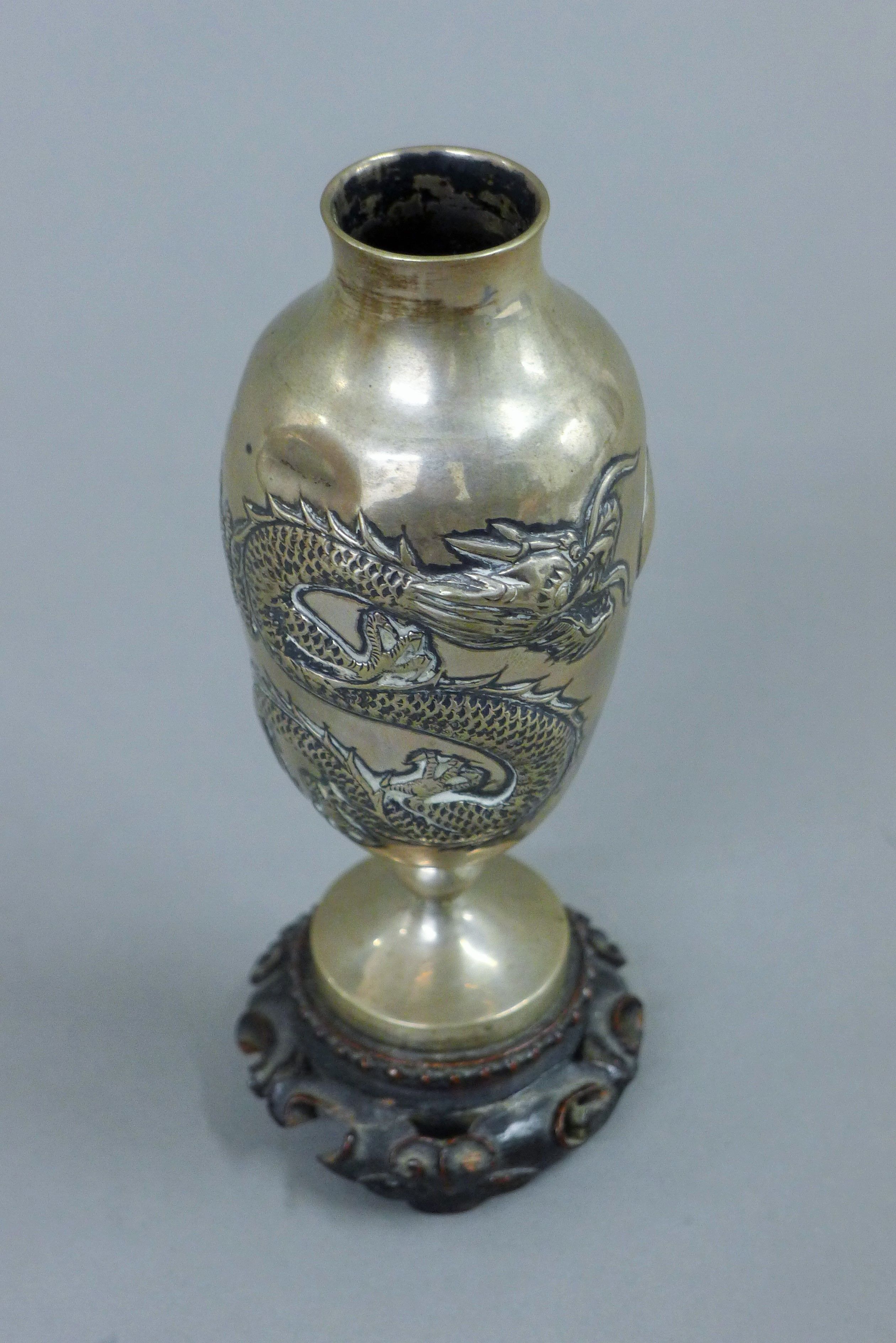 A pair of small Chinese silver vases, each mounted on a carved wooden stand. 14.5 cm high overall. - Image 4 of 5