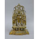 A gilt bronze shrine set with three deities. 28 cm high.