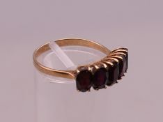 An unmarked gold and garnet ring. Ring size Q. 2.4 grammes total weight.